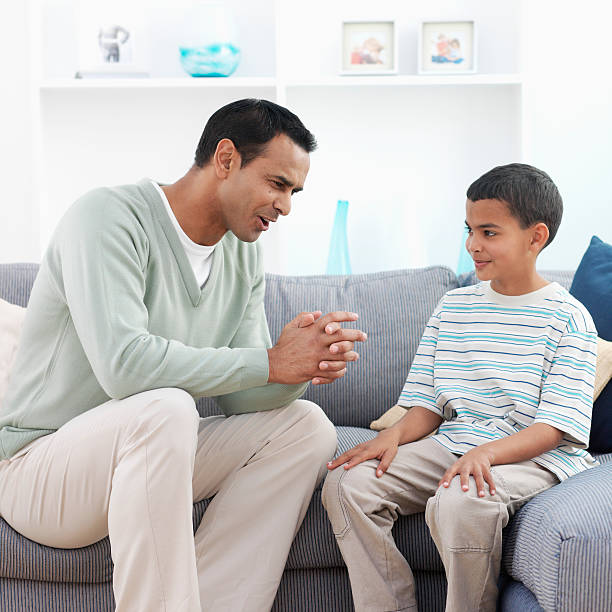 man talking to boy on couch