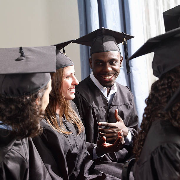 youth with graduation clothing talking and smiling
